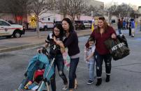 Shoppers with their children react after San Antonio police helped them exit the Rolling Oaks Mall after a deadly shooting Sunday, Jan. 22, 2017, in San Antonio. Authorities say several were injured after a robbery at the shopping mall. (AP Photo/Eric Gay)