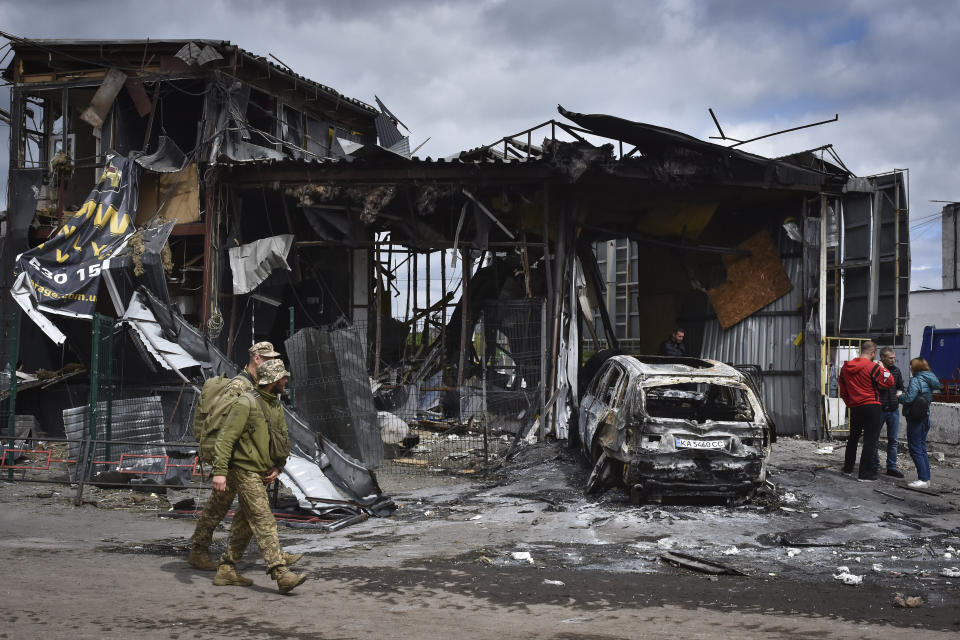 Soldados ucranianos pasan frente a un edificio dañado por un ataque ruso en Dnipró, Ucrania, el viernes 19 de abril de 2024. (AP Foto/Andriy Andriyenko)