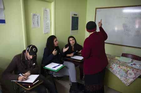 Newly arrived immigrants from France (from L to R) Alexandre Pequito, Myriam Bibas and Aurelie Serraf, all of whom are from Paris, study Hebrew at Ulpan Etzion, the original residential school and absorption centre, which has taught Hebrew to tens of thousands of immigrants since 1949, in Jerusalem, January 20, 2015. REUTERS/Ronen Zvulun