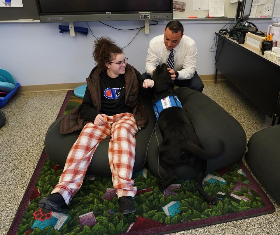 Fieldstone Middle School teacher Mike Morlino interacts with facility dog Maybie and middle-schooler Keighan Benderoth on Thursday, November 2023.