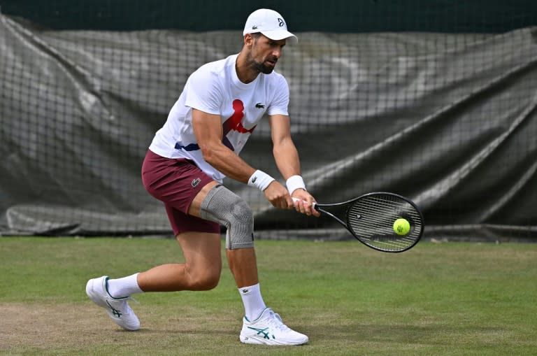 Novak Djokovic, with his knee strapped, takes part in a practice session (Glyn KIRK)