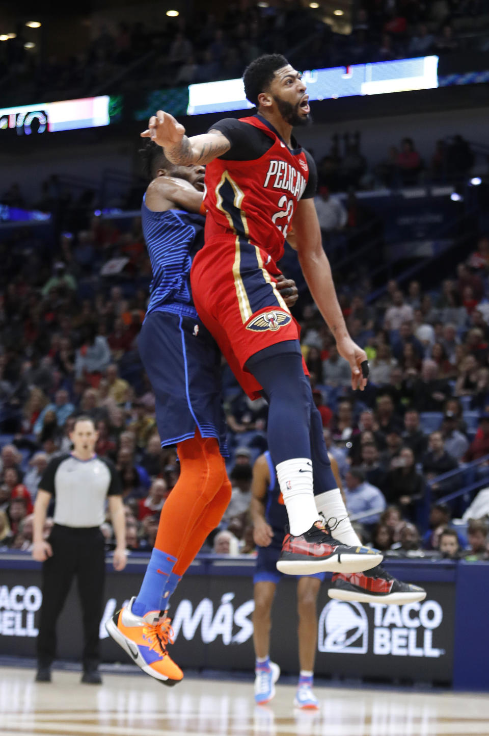 New Orleans Pelicans forward Anthony Davis (23) collides with Oklahoma City Thunder forward Nerlens Noel (3) after attempting to block a shot at the end of the first half of an NBA basketball game in New Orleans, Thursday, Feb. 14, 2019. Davis kept his left arm still as he walked to the locker room shortly after fouling Noel on an attempted shot block with his left hand. When the second half began, the Pelicans announced that Davis was out of the remainder of the game with a left shoulder injury, The Pelicans won 131-122. (AP Photo/Tyler Kaufman)