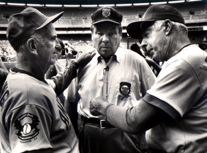 American greats Joe DiMaggio (R) and Luke Appling (L) joke with umpire Jim Honochick July 1, 1985, prior to the start of the Cracker Jack Old Timers baseball Classic, in Washington, D.C. Appling was born on this day in 1907. UPI File Photo