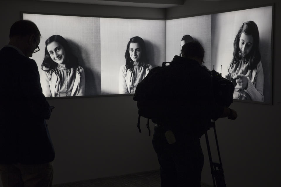 ARCHIVO – Un periodista toma fotografías a imágenes de Ana Frank en el renovado Museo Casa Ana Frank en Ámsterdam, Holanda, el 21 de noviembre de 2018. Un equipo que ha revisado evidencias por cinco años tratando de esclarecer uno de los más grandes misterios de la Segunda Guerra Mundial llegó a lo que califica como “el escenario más probable” sobre quién traicionó a la diarista adolescente Ana Frank y a su familia. (Foto AP/Peter Dejong, archivo)