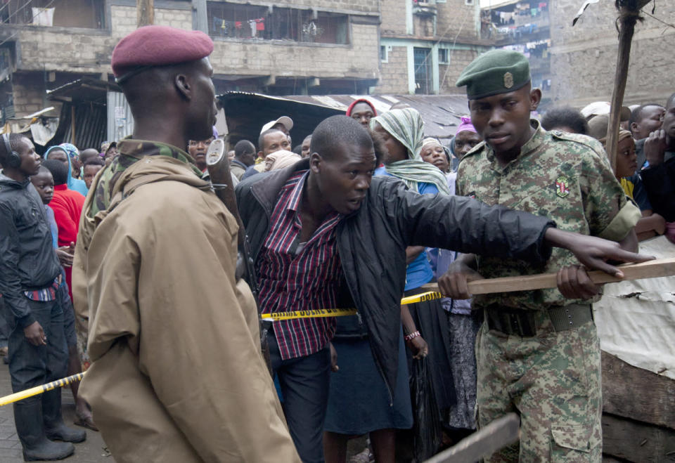 A man is stoppped from crossing the police line