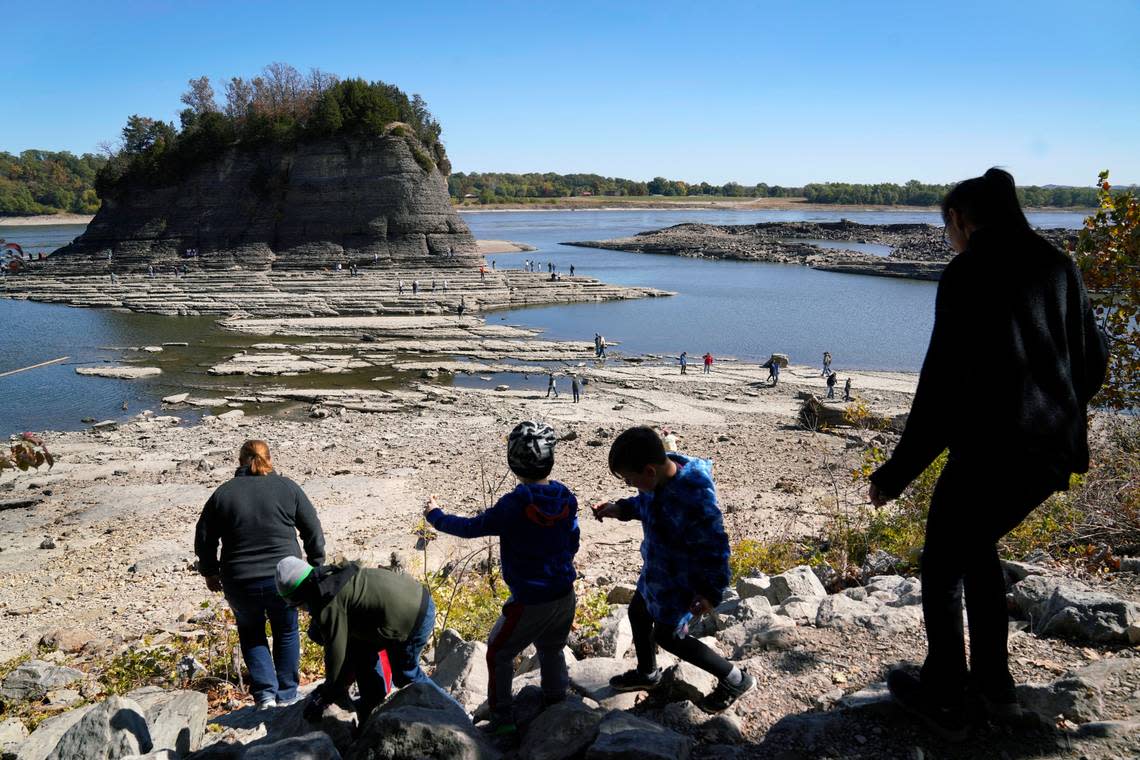 People walk toward Tower Rock to check out the attraction normally surrounded by the Mississippi River and only accessible by boat, Wednesday, Oct. 19, 2022, in Perry County, Mo. Foot traffic to the rock formation has been made possible because of near record low water levels along the river.