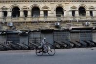 A hawker on bicycle rides past a closed wholesale cloth market during a countrywide strike in Karachi,