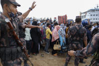 Bangladeshi border guards try to control crowd as thousands of people leaving for their native places to celebrate Eid-al-Fitr throng the Mawa ferry terminal ignoring risks of coronavirus infection in Munshiganj, Bangladesh, Thursday, May 13, 2021. (AP Photo/Mahmud Hossain Opu)