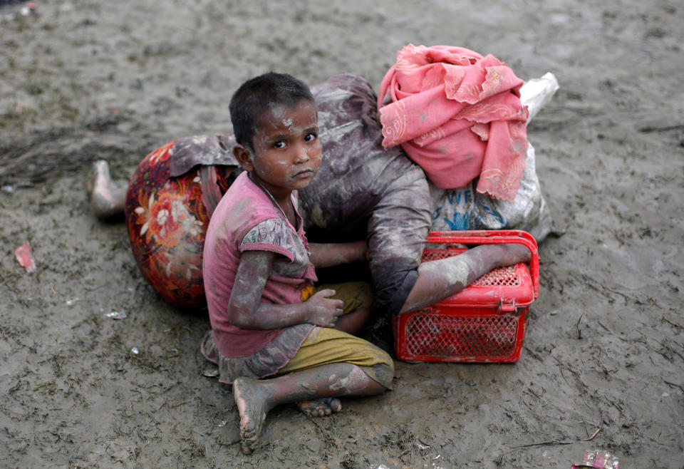 A Rohingya refugee girl sits next to her mother who rests after crossing the Bangladesh-Myanmar border, in Teknaf, Bangladesh, on Sept. 6, 2017.