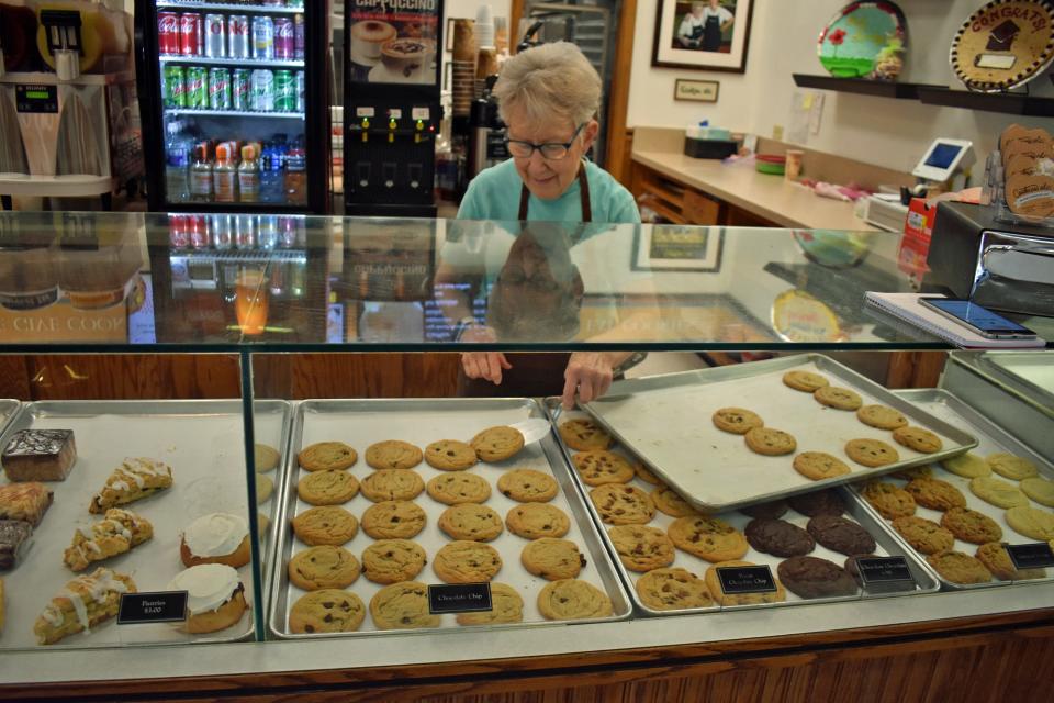 Dorothy Bartels fills the chocolate chip cookie section of the display at Cookies, etc. at North Grand Mall.