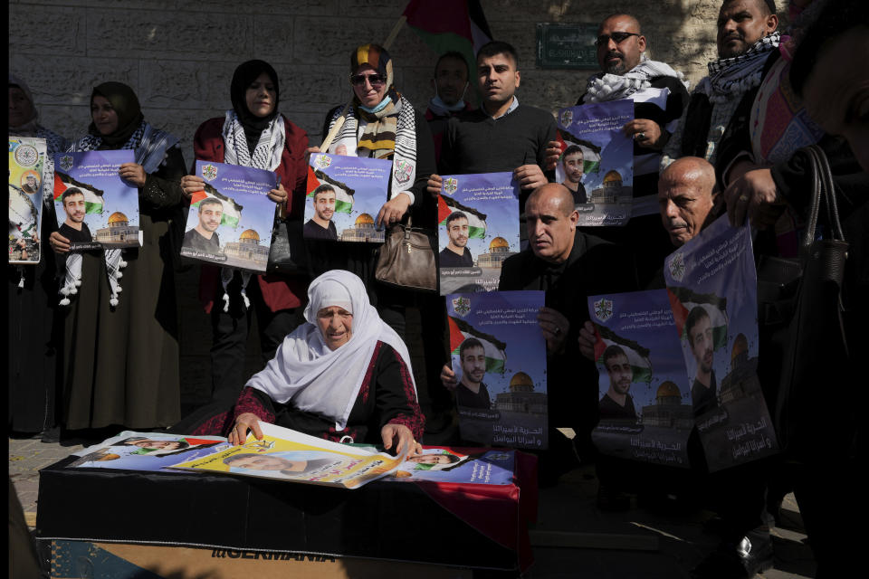 Palestinians react while sitting around a mock coffin as they hold a symbolic funeral of a prisoner Nasser Abu Hamid during a protest in front of the International Committee of the Red Cross office, Tuesday, Dec. 20, 2022, in Gaza City, after he died of lung cancer in Israel. Abu Hamid was a former leader of the Al Aqsa Martyrs' Brigade, the armed wing of Palestinian President Mahmoud Abbas's Fatah party. He had been serving seven life sentences after being convicted in 2002 for involvement in the deaths of seven Israelis during the second Palestinian intifada, or uprising, against Israel's occupation in the early 2000s. (AP Photo/Adel Hana)