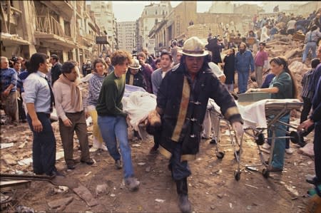 FILE PHOTO: Rescue personnel work after an explosives-laden truck blew up outside the Argentine Israeli Mutual Association (AMIA) building on July 18 1994, in Buenos Aires