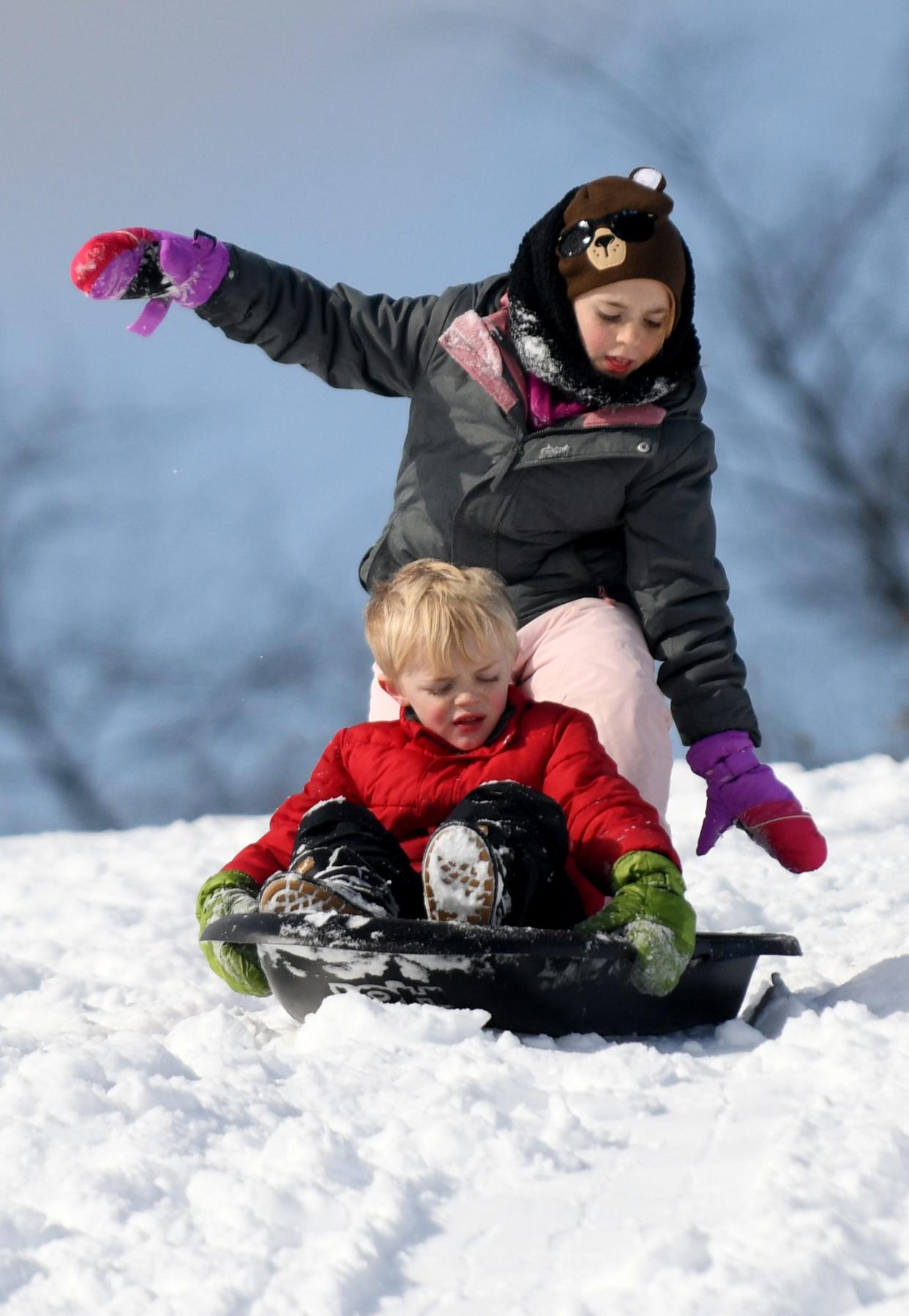 Lucy Steele, 10, from Louisville, gets a ride with brother Henry, 6, while sledding Saturday at Veterans Community Park in Plain Township.