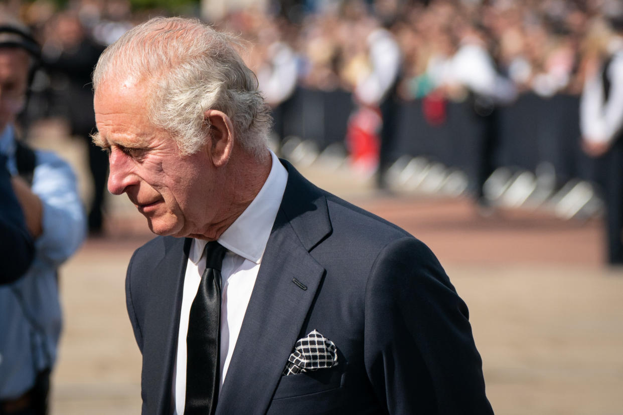 King Charles III looks at flowers outside Buckingham Palace, London after travelling from Balmoral following the death of Queen Elizabeth II on Thursday. Picture date: Friday September 9, 2022.