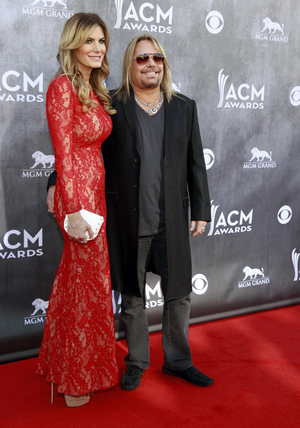 Singer Vince Neil and a guest arrive at the 49th Annual Academy of Country Music Awards in Las Vegas, Nevada April 6, 2014. REUTERS/Steve Marcus (UNITED STATES - Tags: ENTERTAINMENT)(ACMAWARDS-ARRIVALS)