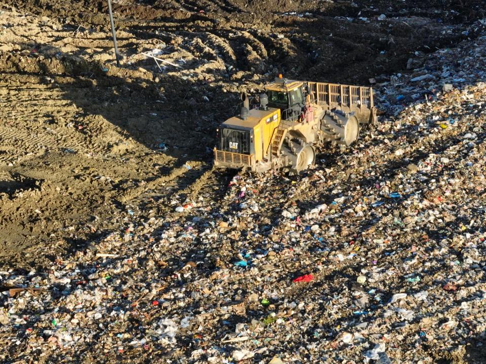 An aerial view of heavy equipment spreading trash.