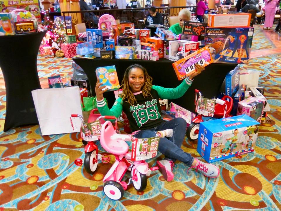 Melanie Spence, of Alpha Theta sorority, is surrounded by toys.