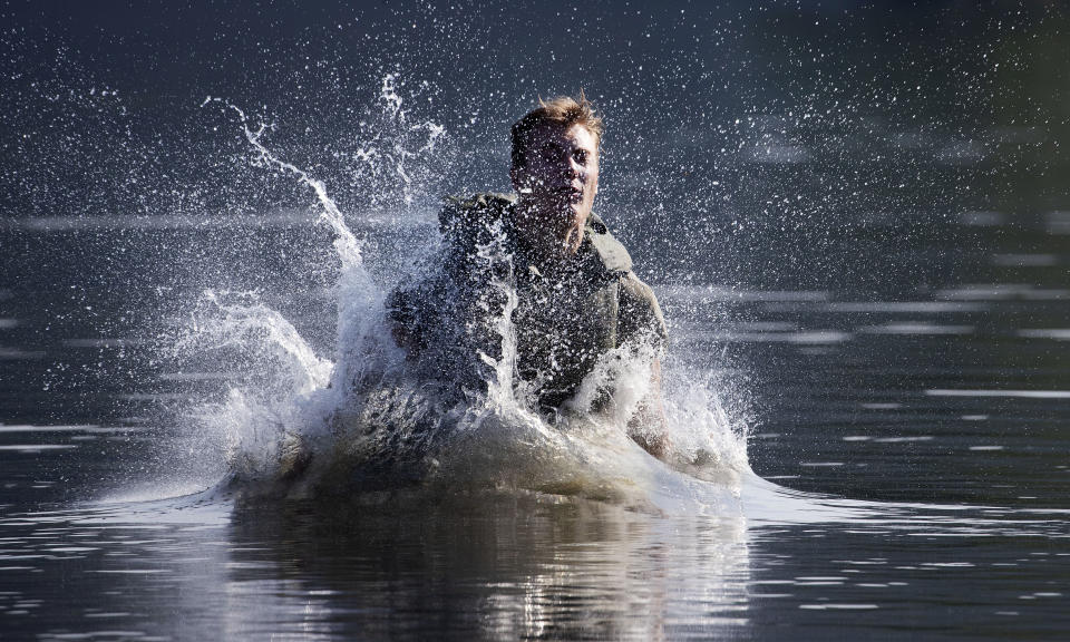 Farrell Thomas, of Lake Forest, Ill., splashes into a lake as he successfully completes a jump in a water obstacle course, Friday, Aug. 7, 2020, in West Point, N.Y. The pandemic is not stopping summer training at West Point. Cadets had to wear masks this year for much of the training in a wooded area just beyond the main gates of the U.S. Military Academy. (AP Photo/Mark Lennihan)