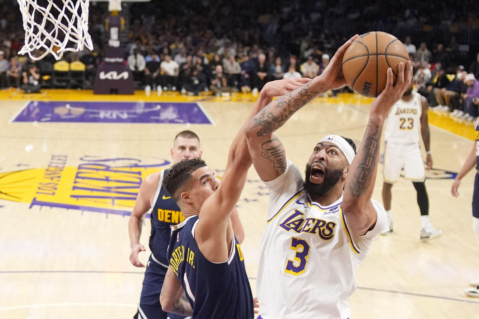Los Angeles Lakers forward Anthony Davis, right, shoots as Denver Nuggets forward Michael Porter Jr. defends during the first half of Game 4 of a first-round playoff basketball series in the NBA, Saturday April 27, 2024, in Los Angeles.  (AP Photo/Mark J. Terrill)