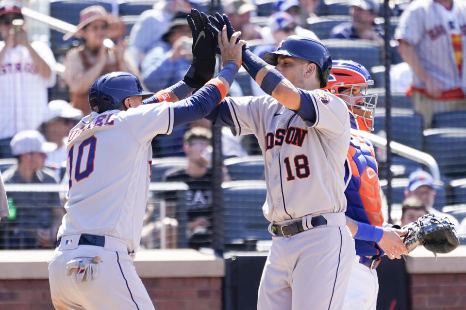Houston Astros' Jason Castro (18) and Yuli Gurriel (10) celebrate after scoring on Castro's two-run home run during the ninth inning of a baseball game against the New York Mets, Wednesday, June 29, 2022, in New York. The Astros won 2-0. (AP Photo/Mary Altaffer)