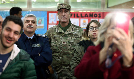 Members of Argentina's security forces and other people look at Argentine President Mauricio Macri (not pictured) as he talks to journalists after casting his vote at a polling station in mid-term primary election in Buenos Aires, Argentina August 13, 2017. REUTERS/Marcos Brindicci