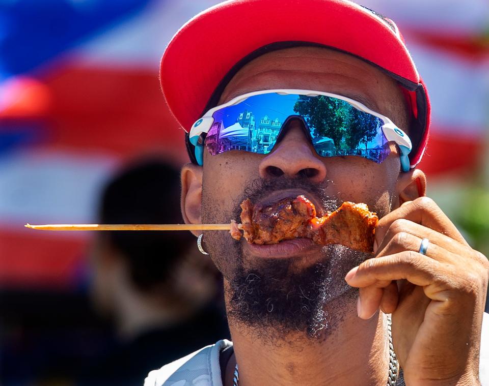 Jermaine Stanford, of Levittown, sinks his teeth into a pork pincho on a stick, during the 49th annual Puerto Rican Day Festival, held in Bristol Borough on Saturday, July 30, 2022.