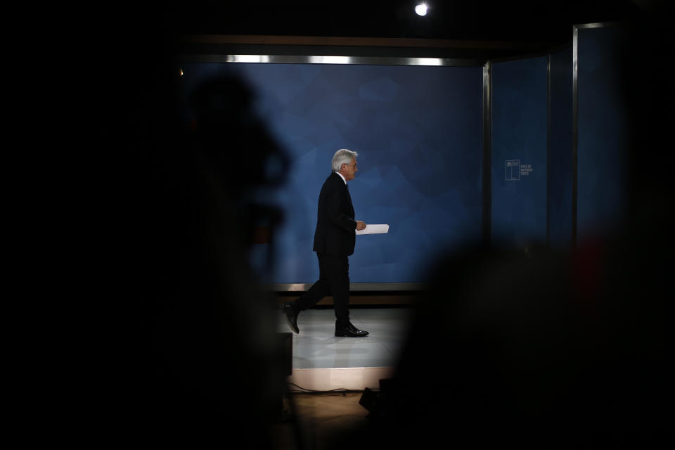 Chilean President Sebastián Piñera exits after addressing the nation from La Moneda presidential palace, amid ongoing demonstrations triggered by an increase in subway fares in Santiago, Chile, Monday, Oct. 21, 2019. Protesters defied an emergency decree and confronted police in Chile’s capital Monday, continuing violent clashes, arson and looting that have left at least 11 dead and led the president to say the country is “at war.” (AP Photo/Luis Hidalgo)