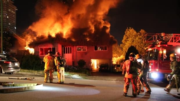 Firefighters are pictured at the scene of a house fire in Burnaby at 9930 Lyndhurst Street early Sunday.  (Ryan Stelting - image credit)