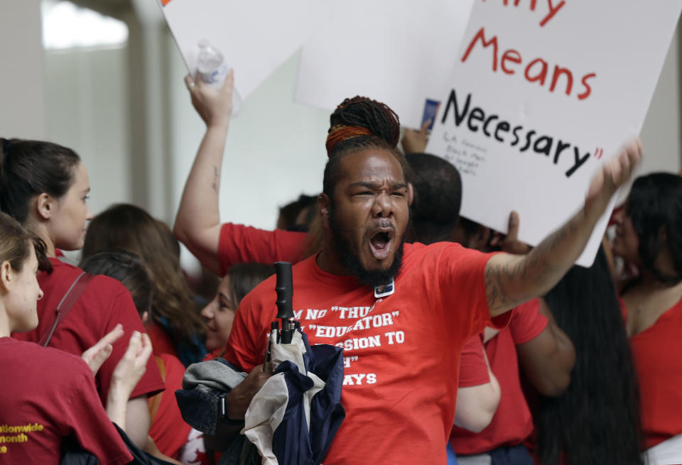 <p>A man encourages the crowd as teachers chant outside the House and Senate chambers during a teachers rally at the General Assembly in Raleigh, N.C., Wednesday, May 16, 2018. (Photo: Gerry Broome/AP) </p>