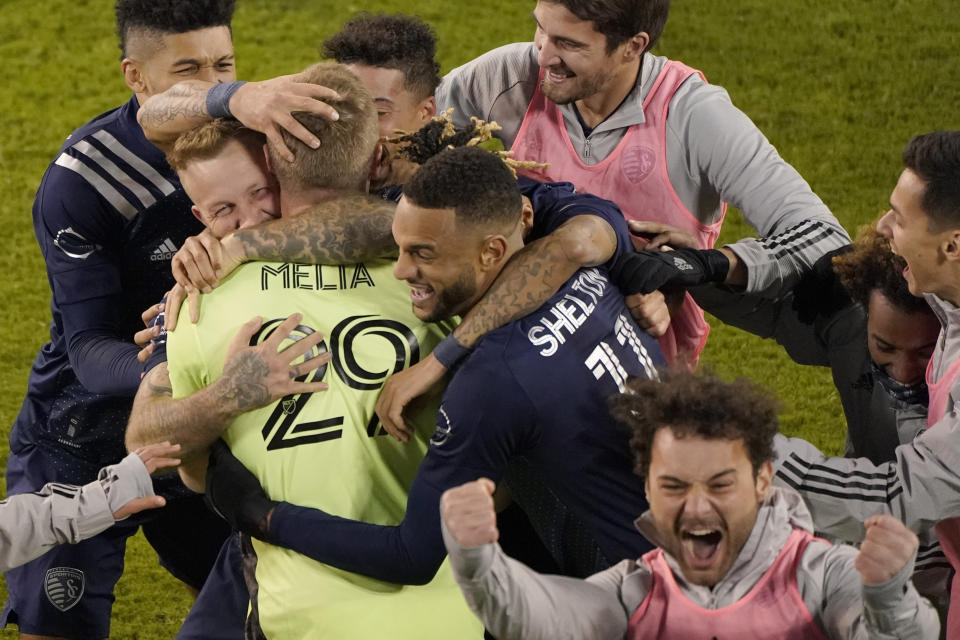 Sporting Kansas City players celebrate after winning an MLS soccer match against the San Jose Earthquakes with a penalty kick in overtime Sunday, Nov. 22, 2020, in Kansas City, Kan. (AP Photo/Charlie Riedel)