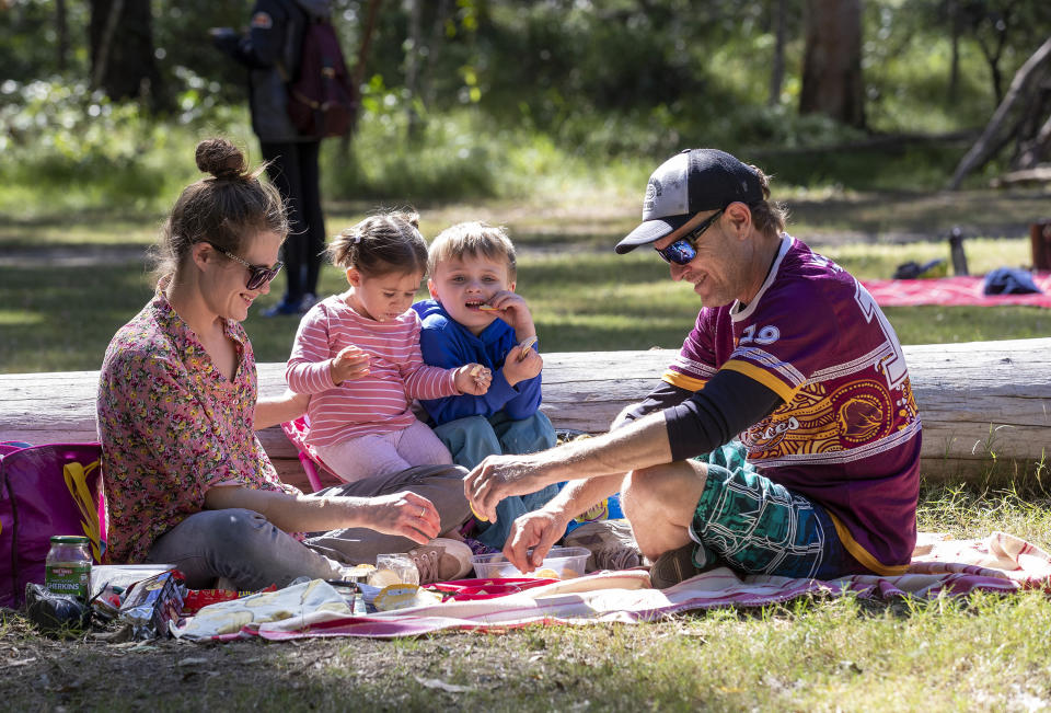 A family enjoys a picnic at Daisy Hill Forest Park in Brisbane. Queenslanders are being urged to continue practicing social distancing as some coronavirus measures are rolled back. Source: AAP