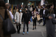 People wearing face masks to curb the spread of coronavirus walk along the Oxford Street shopping area of central London, Wednesday, Oct. 20, 2021. The World Health Organization said there was a 7% rise in new coronavirus cases across Europe last week, the only region in the world where cases increased. Britain, Russia and Turkey accounted for the most cases in Europe. (AP Photo/Matt Dunham)
