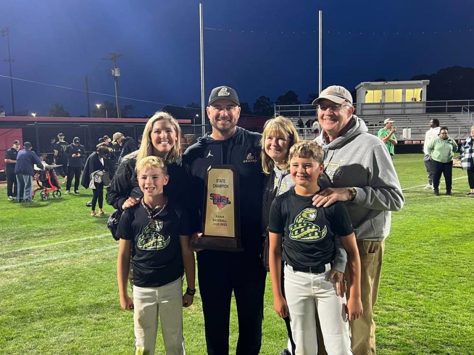 Head coach Stas Swerdzewski (middle, black hat) holds the trophy with his family. He said that the championship win was huge in proving that Catawba Ridge is capable of winning state championships and will instill confidence in future teams.