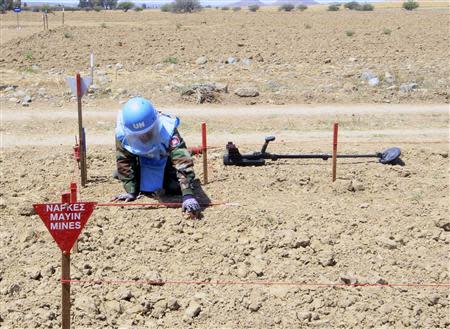 A Cambodian mine clearing expert checks for explosives in a mine hazard area in the United Nations controlled buffer zone, east of the Cypriot capital Nicosia April 23, 2014. REUTERS/Andreas Manolis