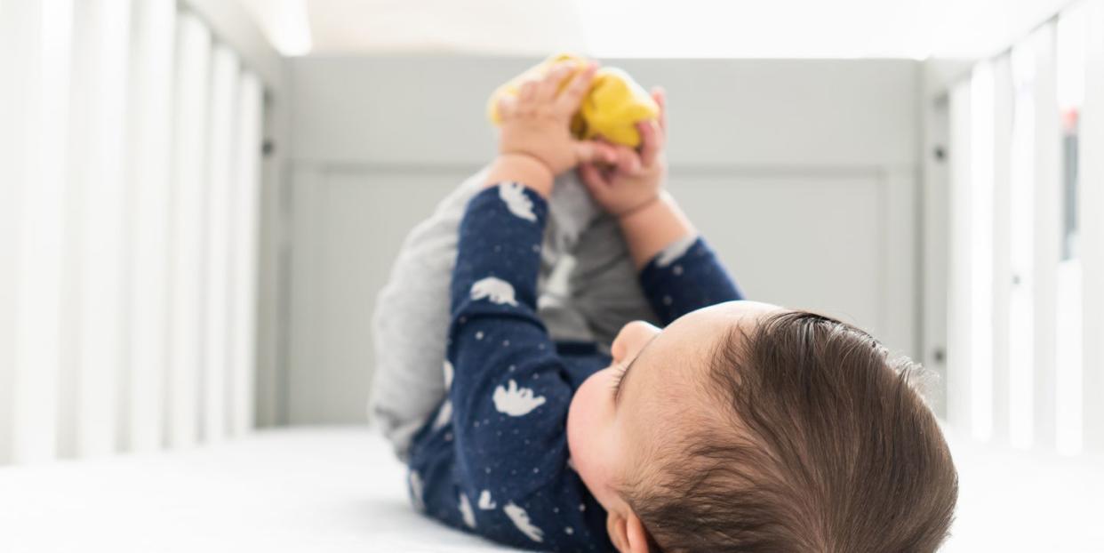 baby playing with feet in crib