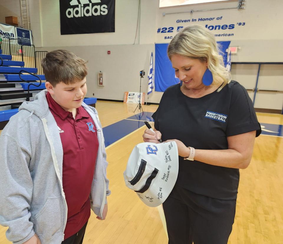 Presbyterian coach Alaura Sharp signs a hat for a young fan at Sunday's selection show event/