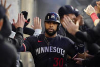 Minnesota Twins' Carlos Santana is congratulated in the dugout after scoring against the Los Angeles Angels during the third inning of a baseball game Saturday, April 27, 2024, in Anaheim, Calif. (AP Photo/Ryan Sun)