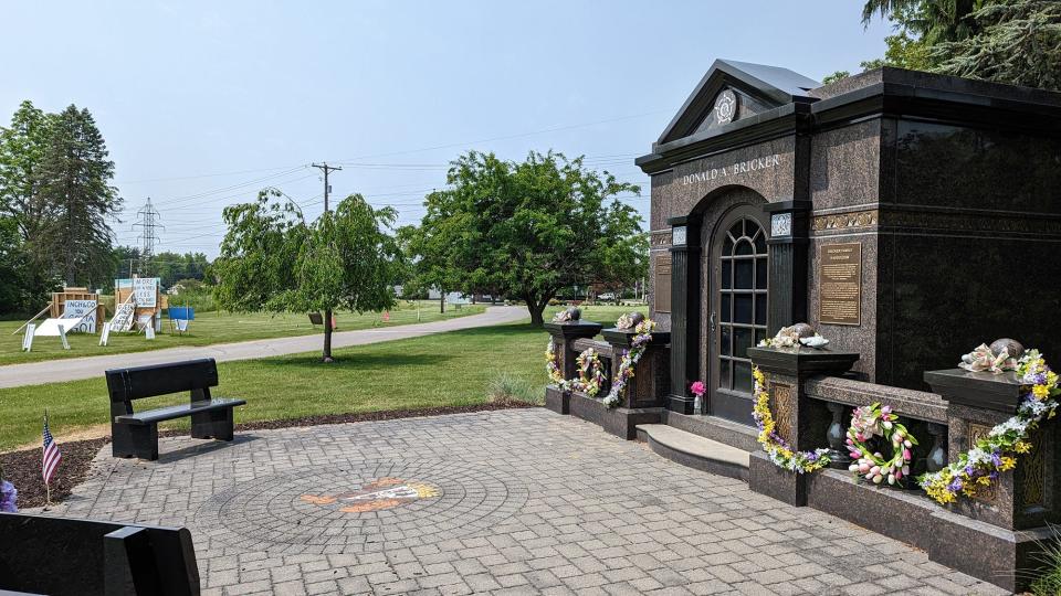 A warehouse could be built across the access road in the background from the Bricker family mausoleum. A large collection of anti-warehouse signs can be seen at left across the street at the beginning of Prospect Hill Cemetery property on May 23, 2023.