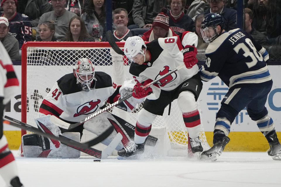 New Jersey Devils goaltender Vitek Vanecek (41) blocks a shot in front of defenseman John Marino (6) and Columbus Blue Jackets center Boone Jenner (38) during the first period of an NHL hockey game Friday, Jan. 19, 2024, in Columbus, Ohio. (AP Photo/Sue Ogrocki)