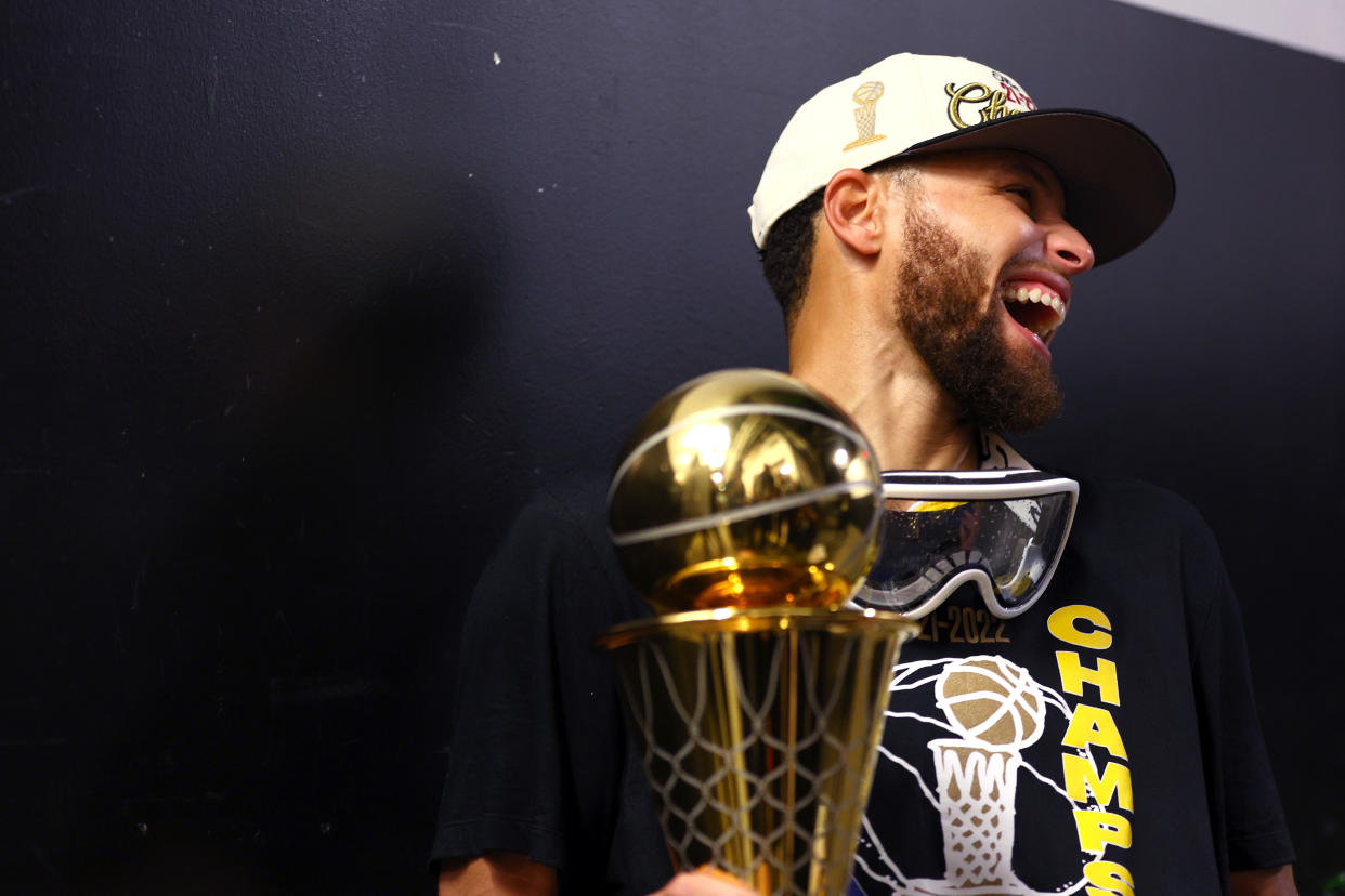 Golden State Warriors superstar Stephen Curry celebrates with the Bill Russell NBA Finals MVP Award after defeating the Boston Celtics in Game 6 of the 2022 NBA Finals at TD Garden in Boston on June 16, 2022. (Elsa/Getty Images)