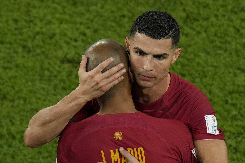 Portugal's Cristiano Ronaldo embraces team mate Joao Mario during his substitution at the World Cup group H soccer match between Portugal and Ghana, at the Stadium 974 in Doha, Qatar, Thursday, Nov. 24, 2022. (AP Photo/Francisco Seco)