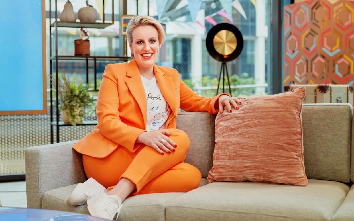 Steph McGovern on a sofa of her TV studio, wearing an orange trouser suit, she is smiling - Tom Barnes/Channel 4 