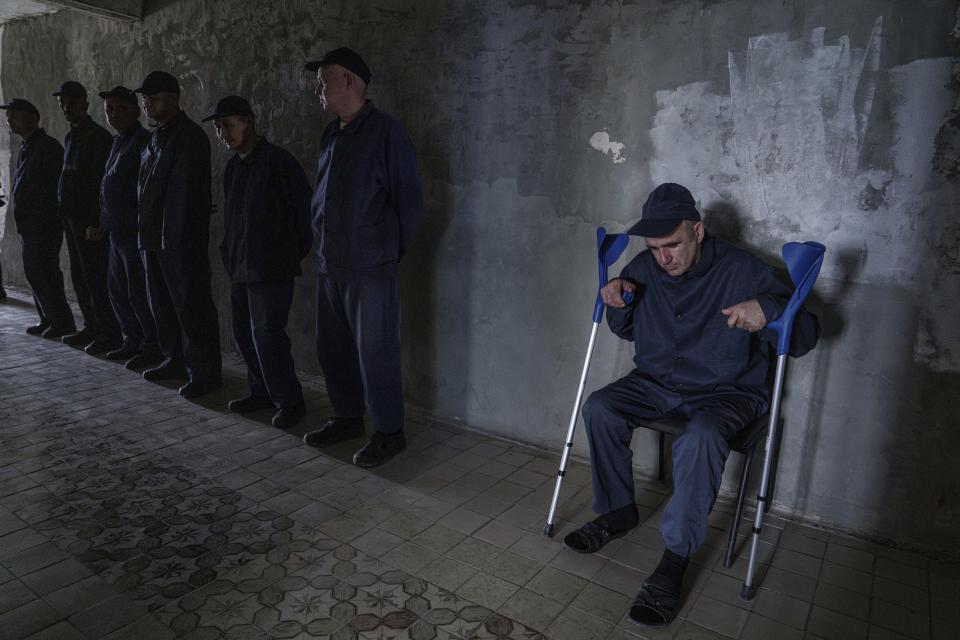 Sergei, an injured Russian prisoner of war, sits in a corridor at the detention center in Ukraine's Lviv region, Thursday, April 25, 2024. AP visited the center as part of a small group of journalists on the condition that its exact location be withheld. (AP Photo/Evgeniy Maloletka)