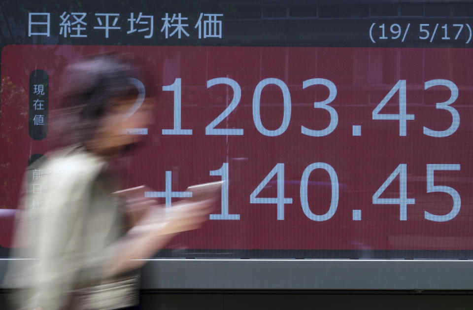 A woman walks past an electronic stock board showing Japan's Nikkei 225 index at a securities firm in Tokyo Friday, May 17, 2019. Asian stocks were mixed on Friday amid worries that U.S. economic sanctions on Huawei would put a drag on trade negotiations with China. (AP Photo/Eugene Hoshiko)