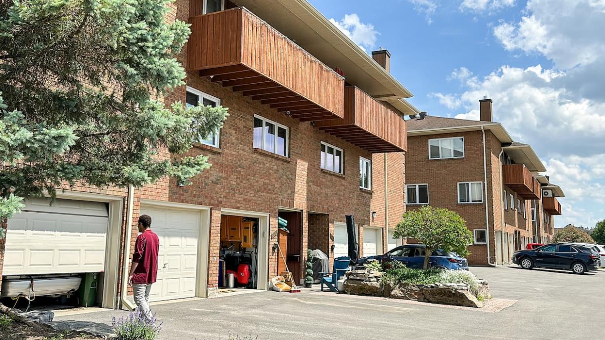 Jonathan Gibson Davis approaches the garage of the Kanata condominium he bought during the pandemic. He's now facing an $11,000 repair bill that's due by the end of the month, and has been told a lien will be placed on his unit if he doesn't meet the June 30 deadline. (Stu Mills/cbc - image credit)