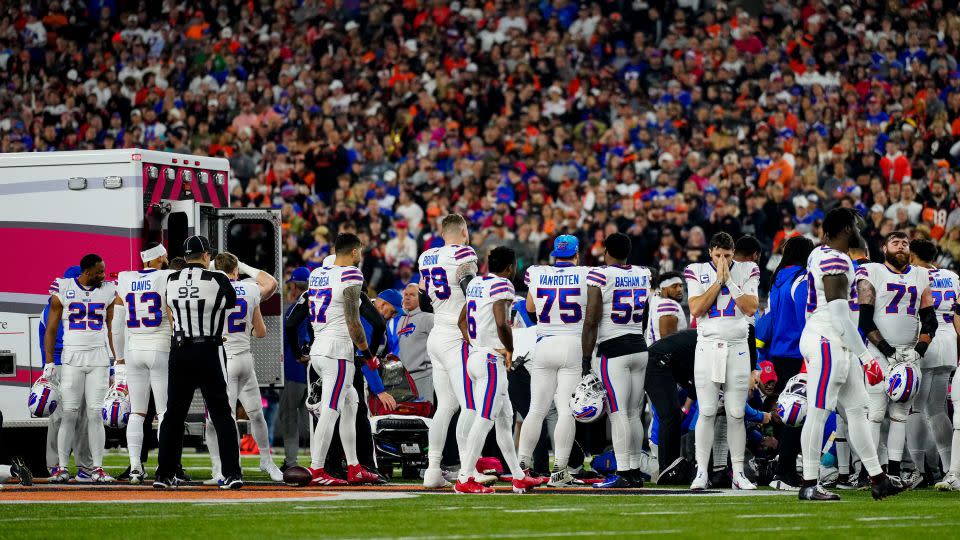 Bills players gather as an ambulance parks on the field at Paycor Stadium, while CPR is administered to Hamlin. The game was suspended with suspended in the first quarter. - Sam Greene/USA Today Sports