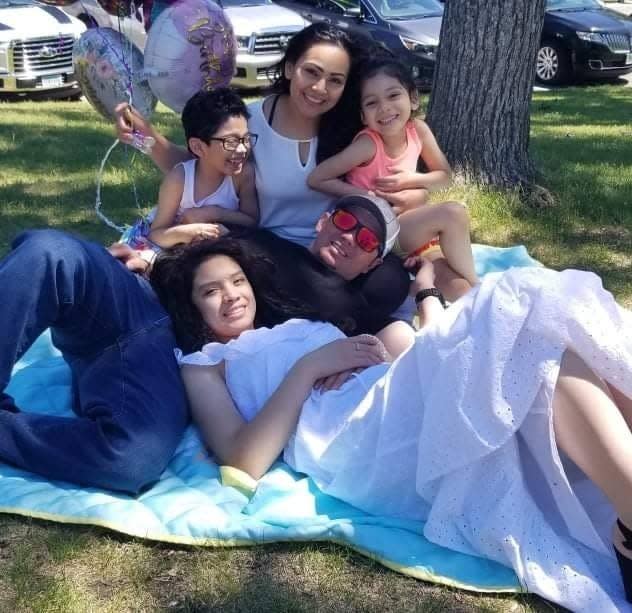 The family, from Moorhead, lying on a picnic rug smiling at the camera.