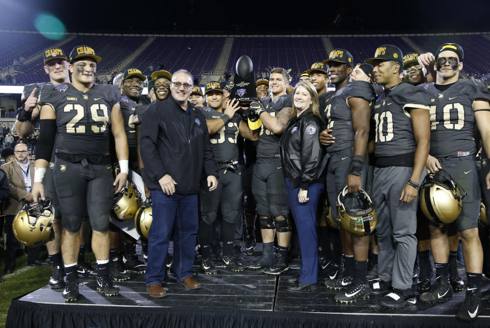 Army teammates pose with the trophy following their team’s 70-14 win over Houston in the Armed Forces Bowl NCAA college football game Saturday, Dec. 22, 2018, in Fort Worth, Texas. (AP Photo/Jim Cowsert)
