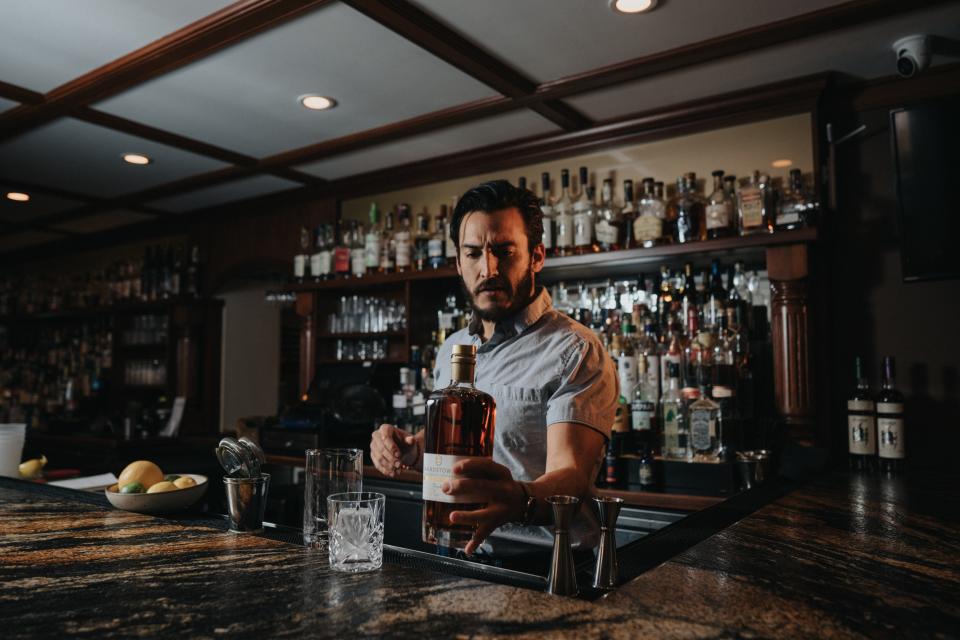 Bar manager Adam Morgan pours whiskey behind the bar at Husk. Husk is one of the many restaurants and bars in the city that devotes big shelf space to whiskey from Tennessee, Kentucky and beyond.