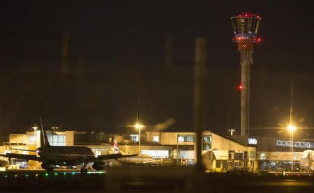 An aircraft taxis next to the control tower at Heathrow airport in London, December 12, 2014. REUTERS/Peter Nicholls